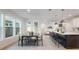 Bright, open-concept dining area with modern light fixtures and a stylish island with bar stool seating at 6525 Rover Way, St Cloud, FL 34771