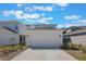 Two car garage with ample parking surrounded by desert landscaping at 6525 Rover Way, St Cloud, FL 34771