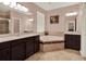 Elegant bathroom with a corner bathtub, dual vanities, and natural light at 7945 Pleasant Pine Cir, Winter Park, FL 32792