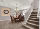 Formal dining room featuring carpet, staircase, modern lighting, and neutral wall tones at 7945 Pleasant Pine Cir, Winter Park, FL 32792