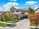 Beautiful two-story home with a well-manicured lawn, mature trees, and a spacious driveway at 7945 Pleasant Pine Cir, Winter Park, FL 32792
