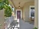 Inviting front porch with a decorative door, hanging light fixture, and a cozy seating area at 7945 Pleasant Pine Cir, Winter Park, FL 32792
