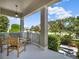 Covered front porch with seating, a view of landscaped yard, and a charming neighborhood setting at 7945 Pleasant Pine Cir, Winter Park, FL 32792