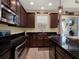 Updated kitchen with stainless steel appliances, dark cabinetry, and granite countertops at 7945 Pleasant Pine Cir, Winter Park, FL 32792
