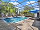 Inviting screened-in pool area with a covered patio, blue umbrellas, sun loungers, and lush landscaping at 7945 Pleasant Pine Cir, Winter Park, FL 32792