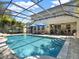 Backyard screened-in pool area with a covered patio, outdoor kitchen, and lush landscaping at 7945 Pleasant Pine Cir, Winter Park, FL 32792