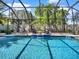Inviting screened-in pool area features waterfall feature, seating, lush landscaping, and clear blue water at 7945 Pleasant Pine Cir, Winter Park, FL 32792