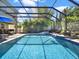 Backyard features screened-in pool, lounge chairs, lush landscaping and an outdoor kitchen with BBQ at 7945 Pleasant Pine Cir, Winter Park, FL 32792