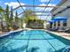 Backyard screened-in pool area features waterfall feature, seating, sun loungers, and lush landscaping at 7945 Pleasant Pine Cir, Winter Park, FL 32792