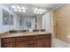 Bathroom with double vanity, granite counters, and combined shower and tub at 8963 Majesty Palm Rd, Kissimmee, FL 34747