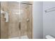 Clean bathroom featuring a glass enclosed shower with beige tiles, towel rack, and silver fixtures at 8963 Majesty Palm Rd, Kissimmee, FL 34747
