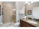 Modern bathroom features a walk-in shower with stone tile and a dark wood vanity at 8963 Majesty Palm Rd, Kissimmee, FL 34747