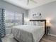Cozy bedroom with a queen bed, gray walls, a ceiling fan, and blue patterned curtains at 8963 Majesty Palm Rd, Kissimmee, FL 34747