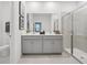 Stylish bathroom featuring dual sinks, a glass-enclosed shower, and modern fixtures at 912 Pearlwood Loop, Eagle Lake, FL 33839