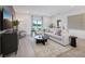 Open-concept living room with a large sectional sofa, sleek furniture, and plenty of natural light at 912 Pearlwood Loop, Eagle Lake, FL 33839