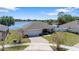 An aerial view showcases the house's proximity to a serene lake, with a well-maintained yard and a brick driveway at 130 Islabella Way, Groveland, FL 34736