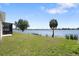 Beautiful backyard with lush green lawn, scenic lake view, and private dock, offering direct water access at 130 Islabella Way, Groveland, FL 34736