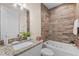 A bathroom with granite vanity and a soaking tub with wood tiled walls at 130 Islabella Way, Groveland, FL 34736