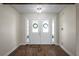 Inviting front entryway with hardwood floors and double doors with decorative wreaths at 130 Islabella Way, Groveland, FL 34736