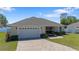 Charming single-story home with a paved driveway, two-car garage, and well-maintained lawn at 130 Islabella Way, Groveland, FL 34736