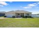 Charming single-story home boasts a lush green lawn, well-manicured landscaping, and an attached two-car garage at 130 Islabella Way, Groveland, FL 34736