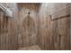 This bathroom features a walk-in shower with wood tile walls and decorative tile flooring at 130 Islabella Way, Groveland, FL 34736