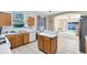 Bright kitchen with a central island, ample counter space, and view of the bonus room and backyard at 14230 Sunriver Ave, Orlando, FL 32828