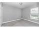 Neutral bedroom features a window with blinds, light gray paint and gray carpet at 14978 Sw 24Th Cir, Ocala, FL 34473