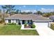 Charming one-story home with a well-manicured lawn, gray exterior, and a two-car garage at 14978 Sw 24Th Cir, Ocala, FL 34473