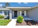 Welcoming front porch with a dark front door, a bright green bush, and a well-maintained yard at 14978 Sw 24Th Cir, Ocala, FL 34473