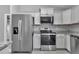 The kitchen features stainless steel appliances, gray cabinets, and stone countertops at 14978 Sw 24Th Cir, Ocala, FL 34473