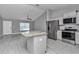 Modern kitchen with stainless steel appliances, a large island, and gray cabinets at 14978 Sw 24Th Cir, Ocala, FL 34473