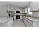 Modern kitchen featuring stainless steel appliances and granite countertops, and gray cabinets at 14978 Sw 24Th Cir, Ocala, FL 34473