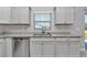 A kitchen featuring stainless steel appliances, gray cabinets, and stone countertops at 14978 Sw 24Th Cir, Ocala, FL 34473