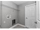 Bright laundry room featuring a metal shelf, neutral paint and tile flooring at 14978 Sw 24Th Cir, Ocala, FL 34473