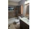 Well-lit bathroom with a tub, toilet, sink, and tiled walls at 1510 Massa St, Kissimmee, FL 34744