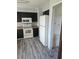 Kitchen featuring wood floors, dark cabinets, and white appliances at 1510 Massa St, Kissimmee, FL 34744