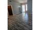 Bright living area with stylish wood-look floors, light gray walls, and a sunlit entrance at 1510 Massa St, Kissimmee, FL 34744
