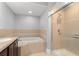 Bathroom featuring soaking tub and glass enclosed shower with light tile surround at 1563 Common Way Rd, Orlando, FL 32814