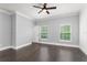 A bright bedroom with hardwood floors, crown molding, baseboards, a ceiling fan and natural light at 1563 Common Way Rd, Orlando, FL 32814