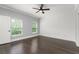 Bright bedroom featuring hardwood floors, two windows, and a ceiling fan at 1563 Common Way Rd, Orlando, FL 32814