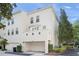 Rear view of a townhouse showcasing a garage, balcony, and manicured landscaping at 1563 Common Way Rd, Orlando, FL 32814