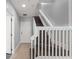 Hallway with a staircase featuring dark wood steps and bright white railings at 1563 Common Way Rd, Orlando, FL 32814