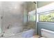 Elegant bathroom features a soaking tub with glass enclosure and large window at 160 Archers Pt., Longwood, FL 32779