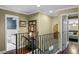 Hallway featuring hardwood floors, iron railing, and access to two bathrooms and a bedroom at 1621 Chippewa Trl, Maitland, FL 32751