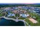 Gorgeous aerial view of Solara Resort featuring a luxurious pool, lake, and beach volleyball court at 1799 Tropical Palms Cir, Kissimmee, FL 34747