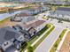 Aerial view of a home with a screened-in patio and lush backyard landscaping in a vibrant community at 1799 Tropical Palms Cir, Kissimmee, FL 34747