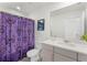 Bright bathroom featuring a Haunted Mansion shower curtain, toilet, sink and mirror at 1799 Tropical Palms Cir, Kissimmee, FL 34747