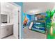 This bedroom boasts a custom bunk bed with a slide and a Moana-themed mural for an adventurous vibe at 1799 Tropical Palms Cir, Kissimmee, FL 34747