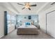 Bright bedroom with a ceiling fan, light blue accent wall, and plush bedding at 1799 Tropical Palms Cir, Kissimmee, FL 34747